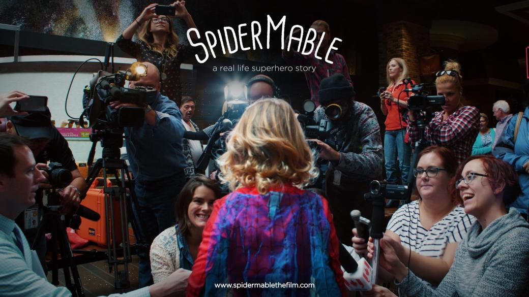 SpiderMable from the back as she speaks to a large group of journalists. 