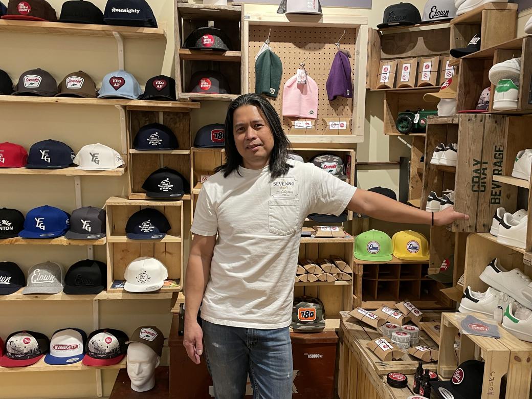 Ador Cochingco stands in front of his Seven80 merchandise.