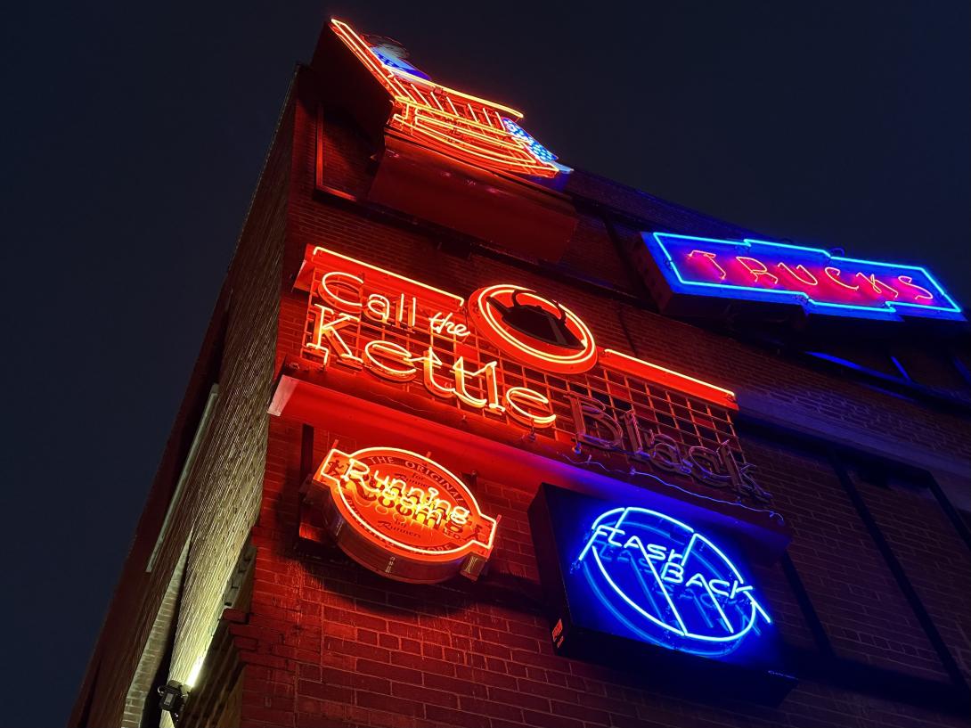 Neon signs for Flashback, Call the Kettle Black, the Running Room and others light up the night on the corner of the Mercer Building.
