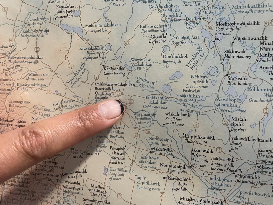 A finger points to amiskwaciy-wâskahikan on a map of Indigenous place names in Canada. 