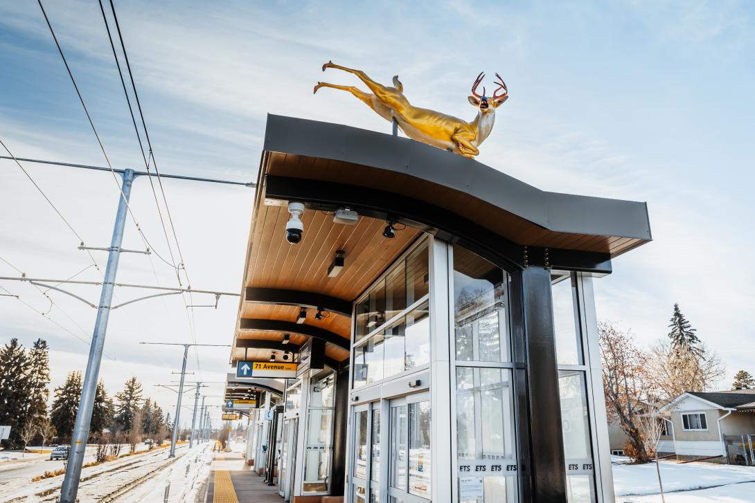 A golden deer sculpture on the roof of an LRT station shelter.