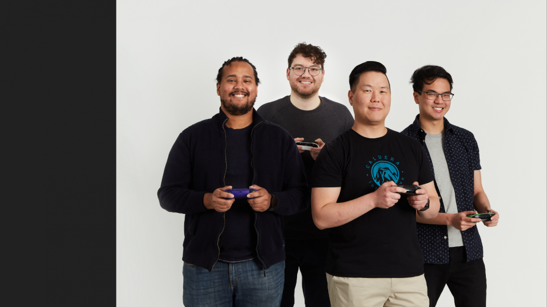 Four men with game consoles in their hands.
