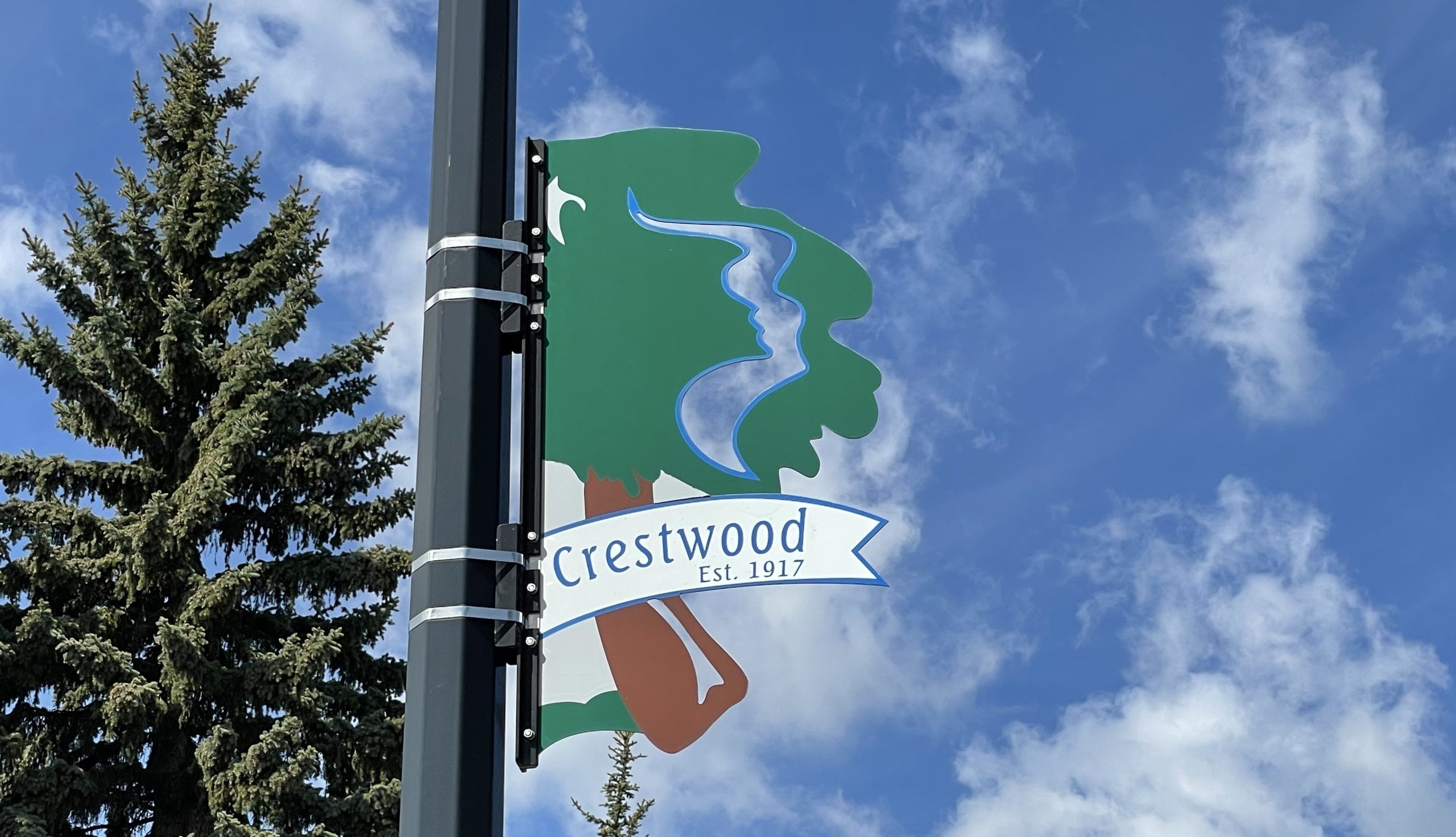 A green tree with 'Crestwood' on a post.