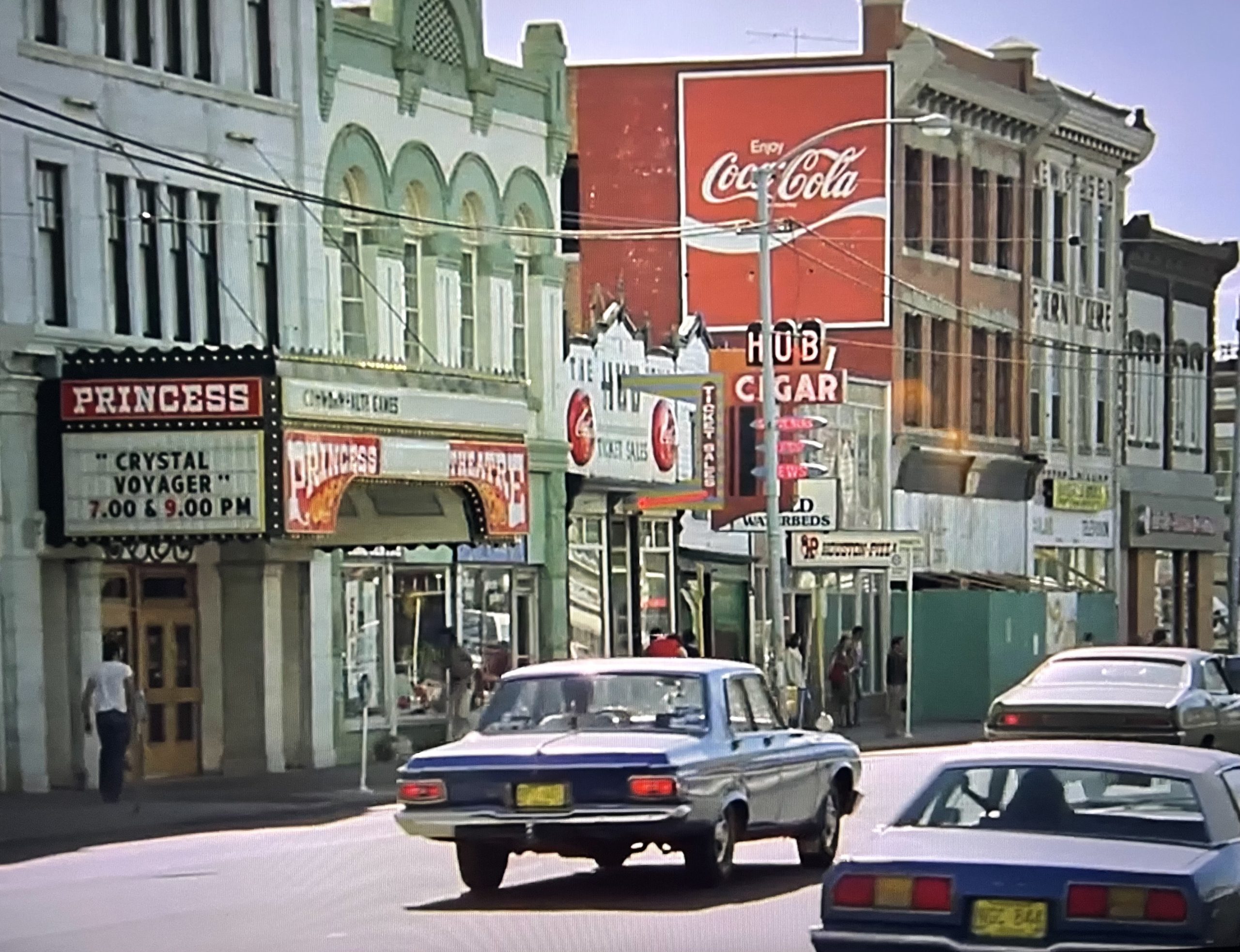 A 70s screenshot of The Princess Theatre on Whyte Avenue with cars on the road.