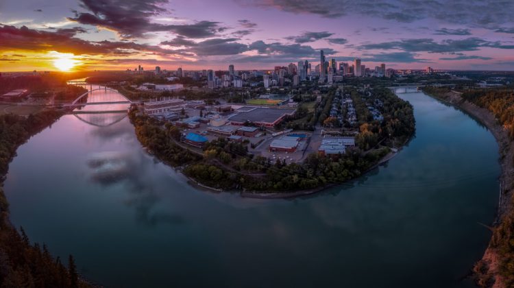 Edmonton skyline with the river curving in the front and sunset in the back.