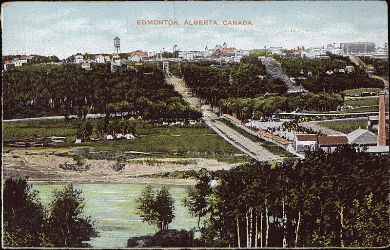 A colourized postcard Edmonton in 1914, featuring the North Saskatchewan River, houses and buildings next to the north bank, and buildings, water towers and churches on top of the hill.