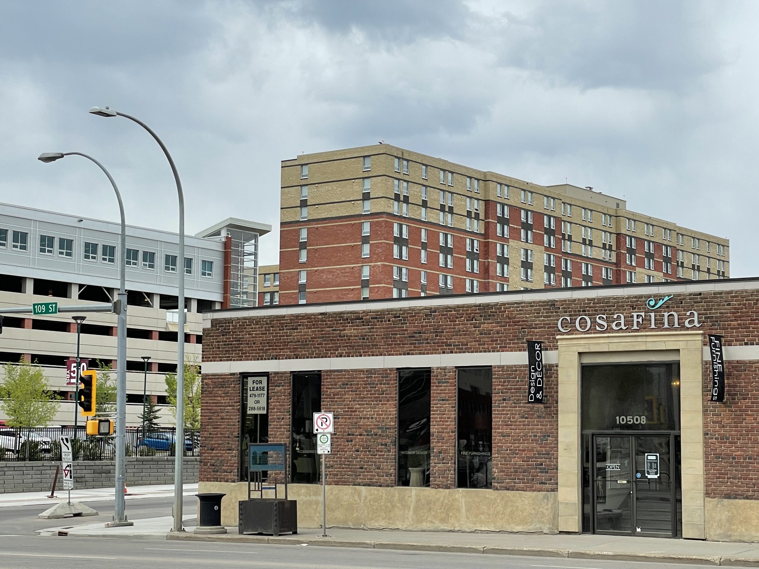 A brick building with a parkade and a student residence in the background.