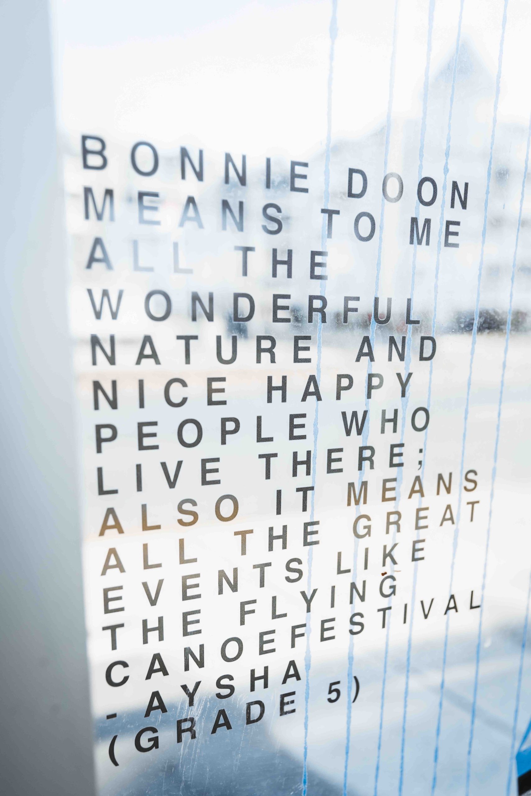 A window in a LRT shelter reads: "Bonnie Doon means to me all the wonderful nature and nice happy people who live there; also it means all the great events like the Flying Canoe Festival." - Aysha (Grade 5)