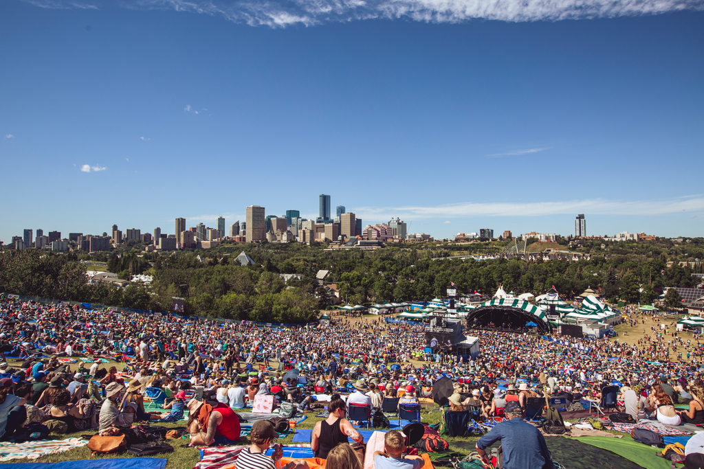 A wide shot of the Folk Fest 2022 crowd with the downtown skyline behind.