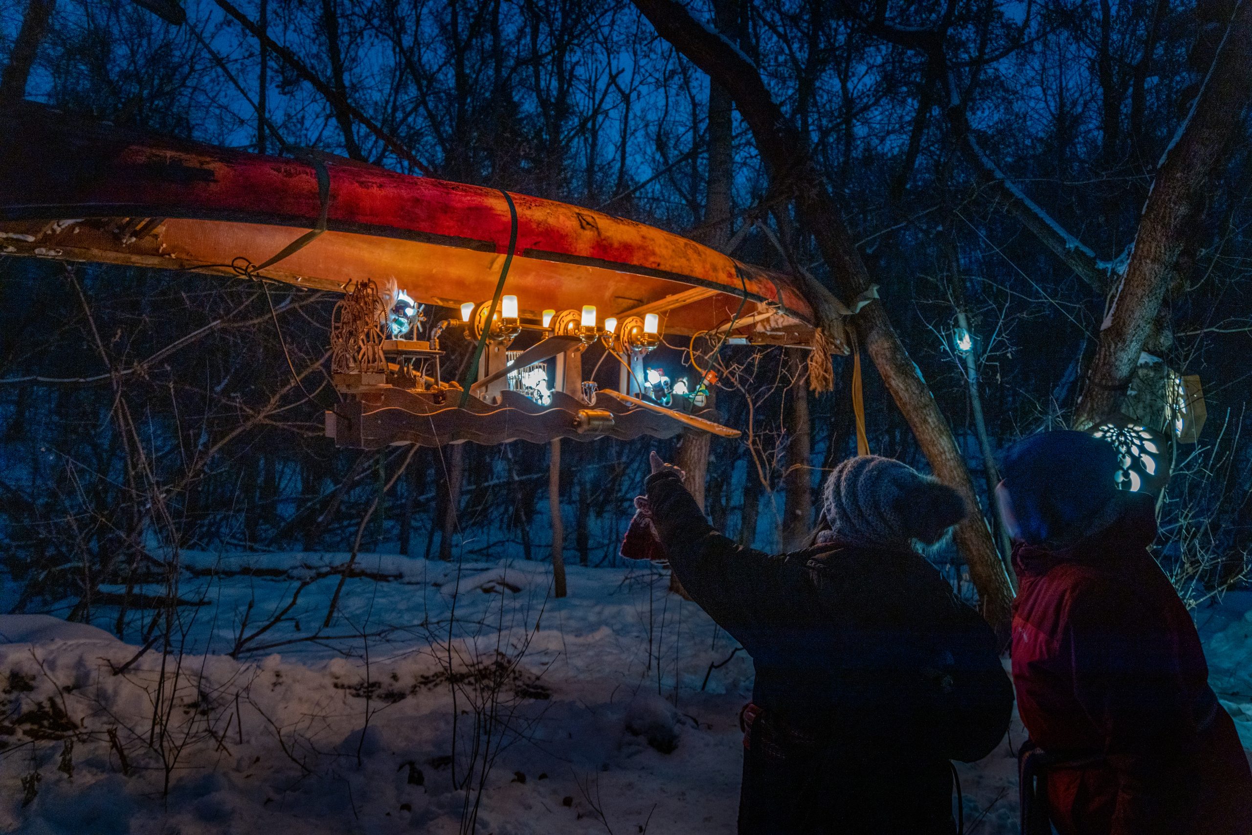 Two people admiring art using a canoe at the Flying Canoë Volant festival.