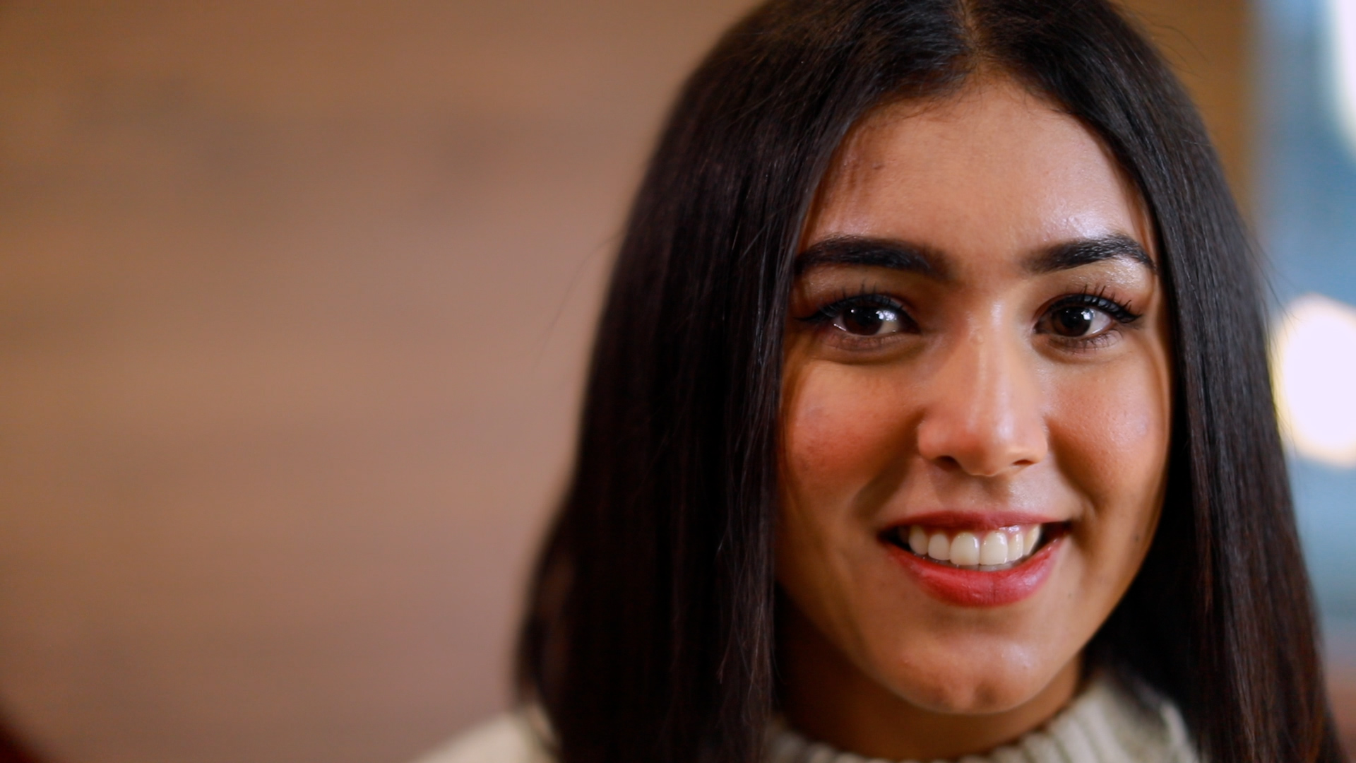 A young woman with straight, dark hair smiling