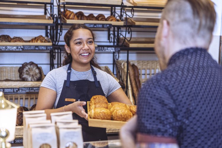 Staff member showing bakery products to customer at the front counter at local bakery Eleanor & Laurent