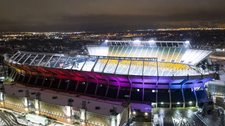 Night aerial of Commonwealth Stadium with rainbow exterior lights
