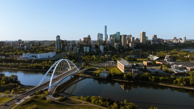 Aerial with downtown skyline behind Walterdale Bridge and Rossdale Power Plant