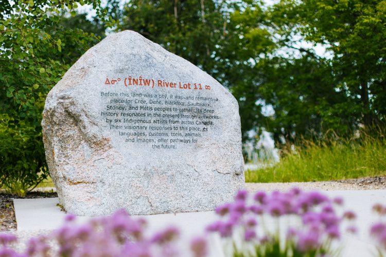 A carved rock explaining the meaning of the Indigenous Art Park : ᐄᓃᐤ (ÎNÎW) River Lot 11∞