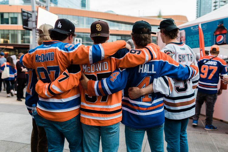 Four fans wearing Oilers jerseys