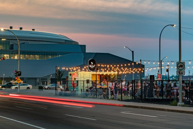 A photo of The Backyard Venue with the Rogers Building behind it during the evening