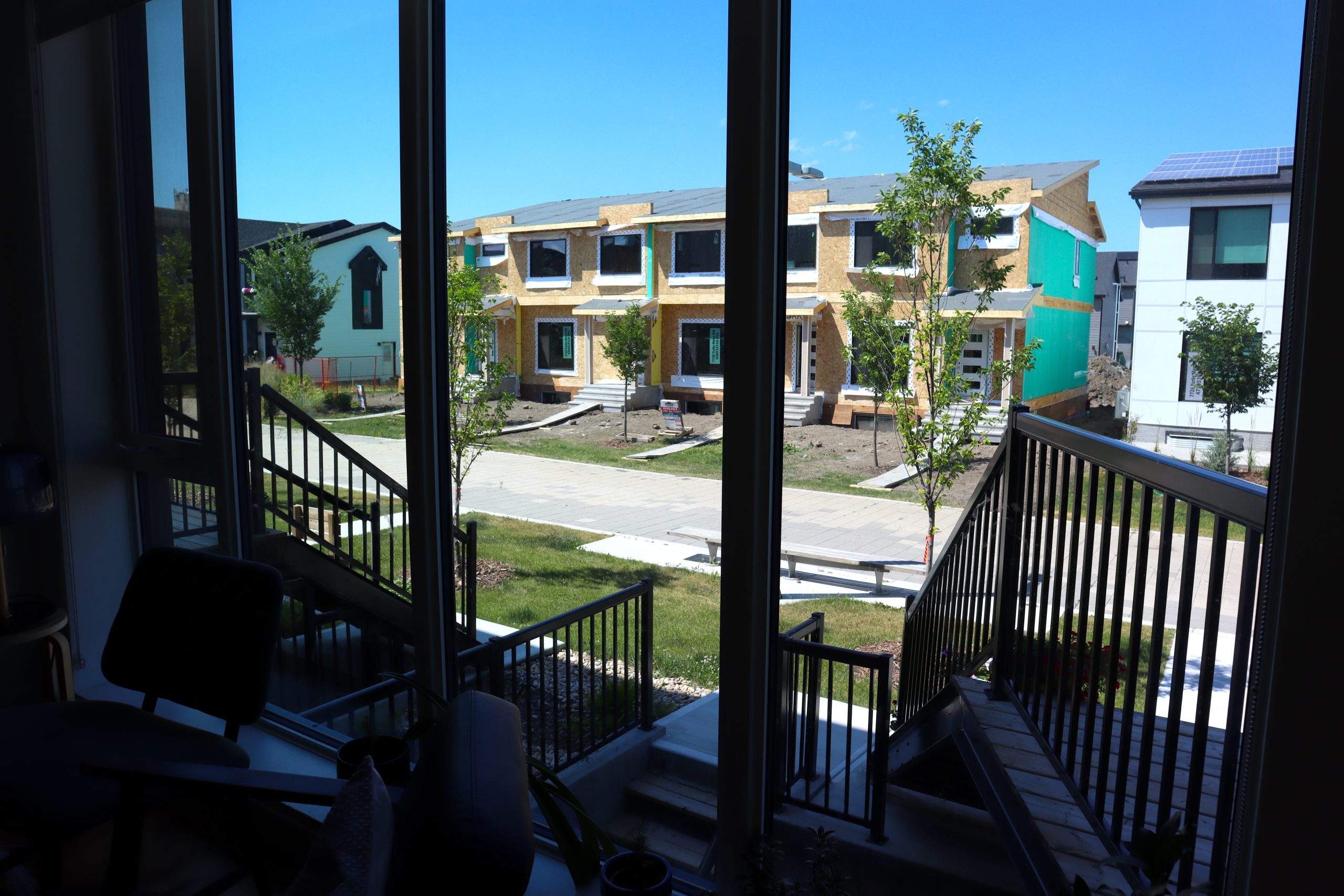 The view out of a front window of a home looking out into a row housing under construction