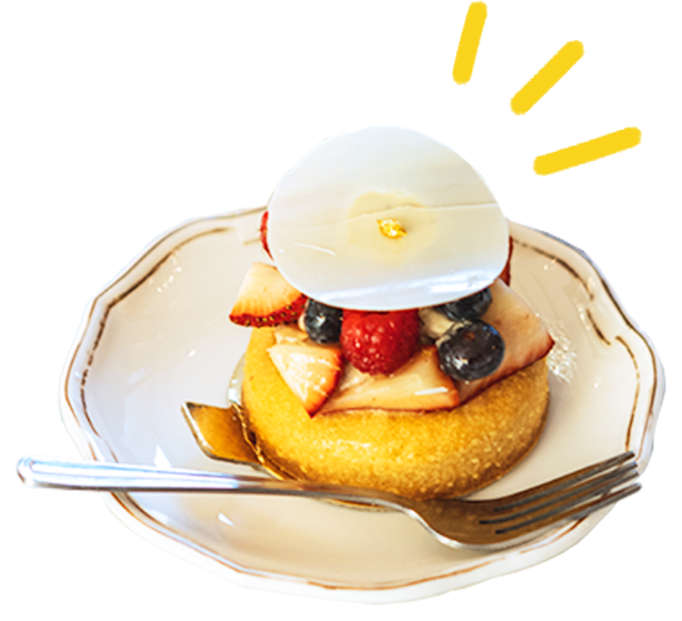 a desert topped with fresh fruit on a white and gold rimmed plate with a fork placed on it