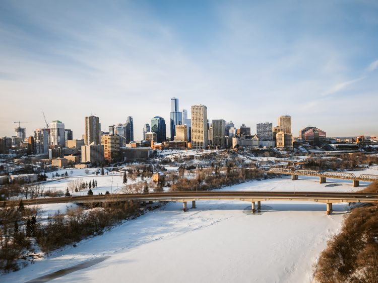 Aerial with two bridges crossing a river with the valley and skyline in winter.
