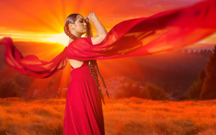An Indigenous woman in a red flowing dress and scarf is superimposed in front of a orange prairie sunset.