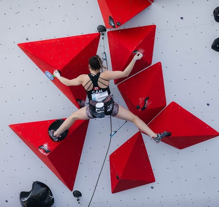 A female climber representing Canada in a wall with 6 red pyramid shaped holds. Credit ClimbYEG.