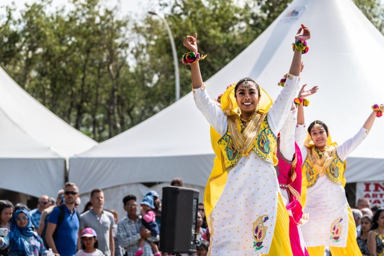 Indian dancers performing on stage at an outdoor festival. Credit: Explore Edmonton