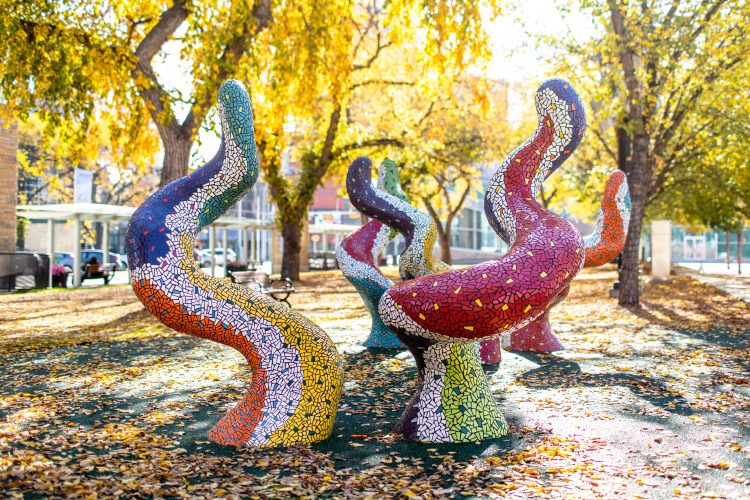 Five colourful creative climb-able public art figures representing a magical forest on a fall day.