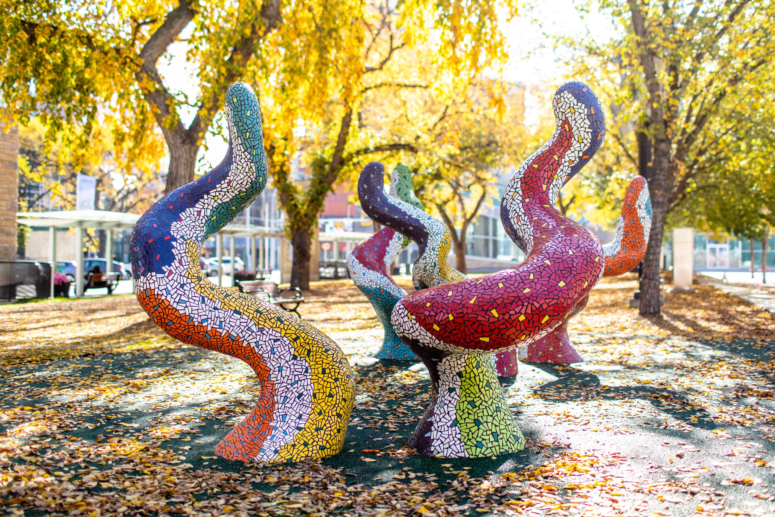 Five colourful creative climb-able public art figures representing a magical forest on a fall day.