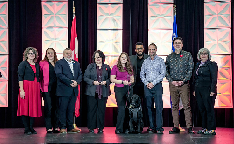 A group of people stand on stage to accept an award.