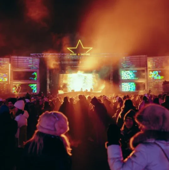A winter crowd watches a music festival stage at night. CR: Igloofest