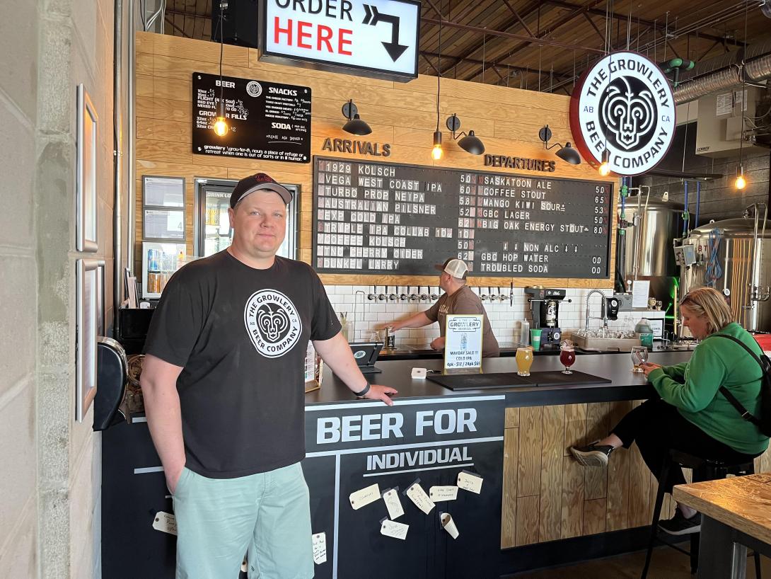 A man standing in front of the counter at a brewery