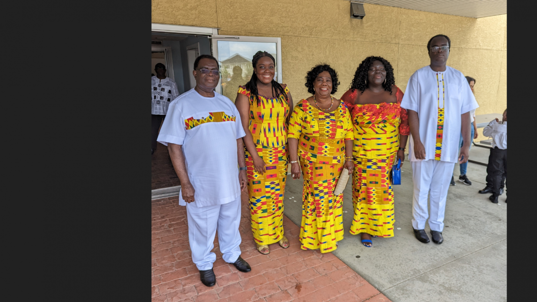 The Adomako-Ansah family wearing traditional Ghanaian clothing. The clothing is bright yellow and white.