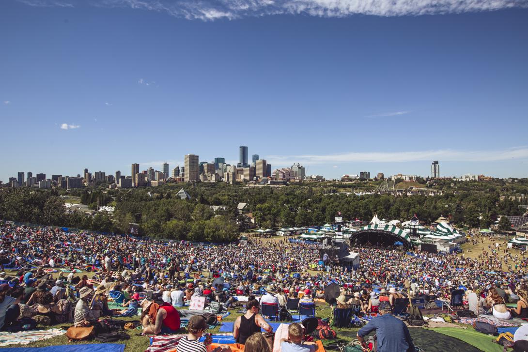 A wide shot of the Folk Fest 2022 crowd with the downtown skyline behind. 